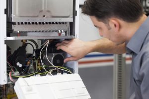 HVAC-technician-working-on-a-heating-system